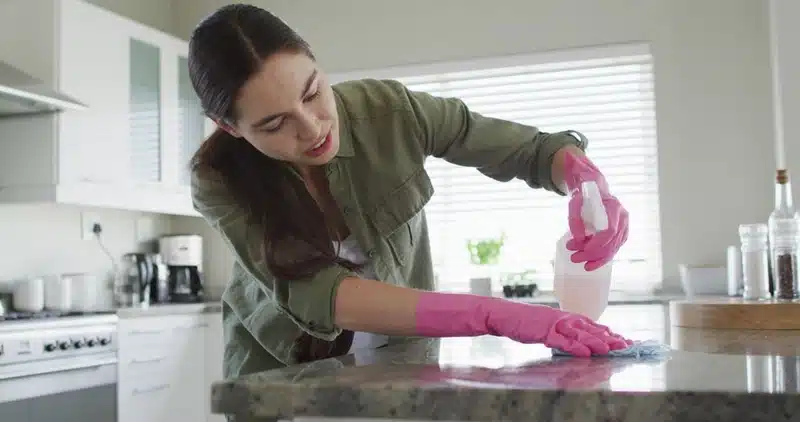 professional cleaner deep cleaning kitchen surfaces in residential home