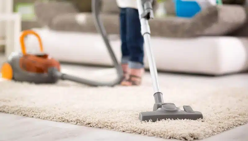 professional vacuuming carpet to remove allergens inside home